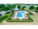 Aerial view of the community pool, featuring a pool house, many chairs for residents and landscaping at 320 Conch Key Way, Sanford, FL 32771