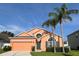 Charming one-story home featuring an attached garage, manicured lawn, and a lovely front yard with palm trees at 320 Conch Key Way, Sanford, FL 32771
