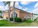 Exterior view featuring a well-maintained lawn, manicured bushes, a fenced yard, and mature palm tree landscaping at 320 Conch Key Way, Sanford, FL 32771