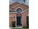 Welcoming home featuring a dark front door and a beautiful arched window above at 320 Conch Key Way, Sanford, FL 32771