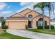 Charming single-Gathering home featuring a well-maintained lawn, two-car garage, and tropical landscaping at 320 Conch Key Way, Sanford, FL 32771