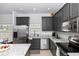 Well-lit kitchen featuring granite countertops, stainless steel appliances, and modern gray cabinetry at 320 Conch Key Way, Sanford, FL 32771