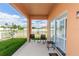 Covered patio featuring chairs and a table, providing a relaxing outdoor space adjacent to the well-maintained backyard at 320 Conch Key Way, Sanford, FL 32771