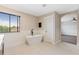 Bright bathroom features a soaking tub beneath a window and leads to the primary bedroom at 3333 Atmore Ter, Ocoee, FL 34761
