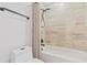 Neutral-tiled shower and tub combination alongside toilet with black hardware and cream shower curtain at 3333 Atmore Ter, Ocoee, FL 34761