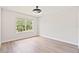 Bedroom with light walls, light wood floors, and a window overlooking the front yard at 3333 Atmore Ter, Ocoee, FL 34761