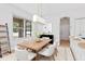 Dining room with a wood table, six white chairs, and a modern chandelier above the table at 3333 Atmore Ter, Ocoee, FL 34761
