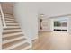 Bright entryway featuring a staircase, white walls, and light wood floors with sliding glass doors leading to a balcony at 3333 Atmore Ter, Ocoee, FL 34761