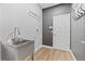 Laundry room features a stainless steel sink, modern wallpaper, and light wood floors at 3333 Atmore Ter, Ocoee, FL 34761