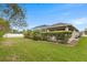 Spacious backyard with lush lawn, mature landscaping, and a screened-in pool at 3470 Tesoro Cir, New Smyrna Beach, FL 32168