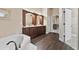 An elegant bathroom featuring a soaking tub, double sink vanity, wood-look floors, and ample natural light at 3470 Tesoro Cir, New Smyrna Beach, FL 32168