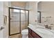Bright bathroom with tiled shower, glass door, granite countertop, and dark wood cabinets at 3470 Tesoro Cir, New Smyrna Beach, FL 32168