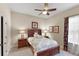 This comfortable bedroom with a ceiling fan features an inviting bed, bedside tables, and warm natural light at 3470 Tesoro Cir, New Smyrna Beach, FL 32168