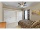 Comfortable bedroom featuring neutral paint, ceiling fan, floral bedspread, and two large closets at 3470 Tesoro Cir, New Smyrna Beach, FL 32168