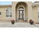 Inviting home entryway with stylish glass door and decorative planters at 3470 Tesoro Cir, New Smyrna Beach, FL 32168