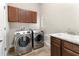Laundry room features stainless steel washer and dryer, granite countertops and wooden cabinets at 3470 Tesoro Cir, New Smyrna Beach, FL 32168