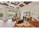 Spacious living room featuring coffered ceilings, wood floors, and sliding glass doors to a pool area at 3470 Tesoro Cir, New Smyrna Beach, FL 32168