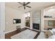 Bright living room featuring a stone fireplace, built-in shelving, ceiling fan, and hardwood floors at 3470 Tesoro Cir, New Smyrna Beach, FL 32168