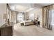 Spacious main bedroom featuring neutral walls, tray ceiling, ceiling fan, and large windows at 3470 Tesoro Cir, New Smyrna Beach, FL 32168