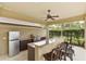 Outdoor kitchen featuring a stainless steel grill, refrigerator, sink, and bar seating at 3470 Tesoro Cir, New Smyrna Beach, FL 32168