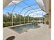 Screened-in pool has waterfall features and is surrounded by concrete deck at 3470 Tesoro Cir, New Smyrna Beach, FL 32168
