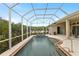 Enclosed pool has waterfall feature and overlooks lush landscaping and blue sky at 3470 Tesoro Cir, New Smyrna Beach, FL 32168