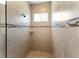 Tiled shower with a mosaic accent stripe, a shower caddy and a shower head at 3470 Tesoro Cir, New Smyrna Beach, FL 32168