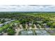 Aerial view showcases single-Gathering homes with tennis courts and a scenic pond at 38 Lake Walden Trl, Ormond Beach, FL 32174