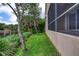 Backyard view of the side of the home with a screened porch overlooking a pond at 38 Lake Walden Trl, Ormond Beach, FL 32174