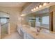 Bathroom featuring dual sinks, a large mirror, a glass shower, and a soaking tub at 38 Lake Walden Trl, Ormond Beach, FL 32174