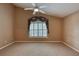 Bright, carpeted bedroom with a vaulted ceiling and a ceiling fan above a large window at 38 Lake Walden Trl, Ormond Beach, FL 32174