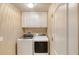 Bright laundry room featuring modern washer and dryer, with white cabinets above for storage at 38 Lake Walden Trl, Ormond Beach, FL 32174