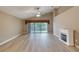 Bright living room featuring a fireplace, ceiling fan, and a sliding glass door with water view at 38 Lake Walden Trl, Ormond Beach, FL 32174