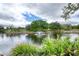 Scenic view of pond featuring a fountain, lush greenery, and clear blue skies at 38 Lake Walden Trl, Ormond Beach, FL 32174