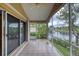 A tiled, screened-in porch overlooking a lake with tropical foliage and a ceiling fan at 38 Lake Walden Trl, Ormond Beach, FL 32174