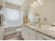 Bright bathroom featuring a granite countertop, stylish vanity, decorative towels, and a tub with a tropical-themed shower curtain at 3817 Islamorada Dr, Ormond Beach, FL 32176
