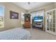A cozy bedroom with a bed, dresser, and large windows offering natural light and view of lush scenery at 3817 Islamorada Dr, Ormond Beach, FL 32176