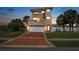 Charming three-story home featuring two balconies, a two-car garage, and a well-manicured lawn at 3817 Islamorada Dr, Ormond Beach, FL 32176