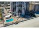 Aerial view of a beachfront condo building showcasing pool, parking, and beach access at 3855 S Atlantic Ave # 405, Daytona Beach, FL 32118