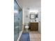 Bathroom featuring a glass shower, neutral colored tile, and a decorative vanity at 3855 S Atlantic Ave # 405, Daytona Beach, FL 32118