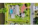 Aerial view showcasing a home's backyard pool, adjacent pond, surrounding greenery, and driveway at 4 Huntsman Look, Ormond Beach, FL 32174