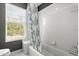 Bathroom featuring a tiled wall, bathtub with shower curtain, and window with natural light at 4 Huntsman Look, Ormond Beach, FL 32174