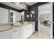 Bathroom features dual sinks, white cabinets, a well-lit vanity mirror, and a glimpse into a separate room at 4 Huntsman Look, Ormond Beach, FL 32174