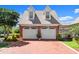 A two-car garage with charming architectural details and a brick driveway at 4 Huntsman Look, Ormond Beach, FL 32174