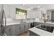 Contemporary kitchen with gray cabinets, granite countertops, and a window above the sink with patterned valance at 4 Huntsman Look, Ormond Beach, FL 32174