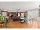 Spacious living room with hardwood floors, brown couches, and a ping pong table near sliding glass doors at 4 Huntsman Look, Ormond Beach, FL 32174