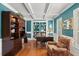Stylish office with custom built-in shelving, comfortable seating, and a large desk, illuminated by natural light at 4 Huntsman Look, Ormond Beach, FL 32174