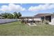Lush backyard featuring a covered patio area with seating and a grill, ideal for entertaining at 417 Jeffers St, Deltona, FL 32725