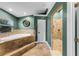 The bathroom features a corner soaking tub, tile flooring, a window, and connects to the tiled walk-in shower at 426 N Boyd St, Winter Garden, FL 34787