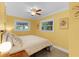 Bright bedroom featuring a ceiling fan, warm yellow walls, and natural light from the windows at 426 N Boyd St, Winter Garden, FL 34787